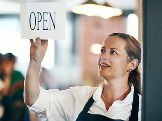 Image showing Look at where vision will take you. a mature woman hanging up an open sign on the door of a cafe.