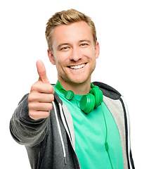 Image showing Youre doing great. a handsome young man standing alone in the studio and showing a thumbs up.