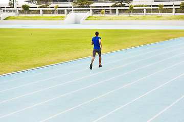 Image showing Long distance is his game. Rearview shot of an unrecognizable young male athlete running along the track.
