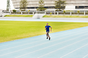 Image showing The final stretch. Full length shot of a handsome young male athlete running along the track.