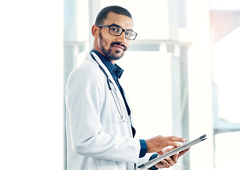 Image showing Patient info at the tap of an icon. Portrait of a young doctor using a digital tablet in a modern hospital.