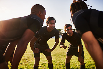 Image showing Coming up with a game plan. a diverse group of sportsmen huddled together before playing a game of rugby.