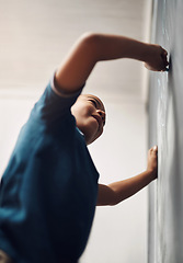 Image showing When their imagination takes flight, limitless possibilities open up. a young boy writing on a blackboard at home.