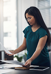 Image showing Shes quite thorough when it comes to planning. a young businesswoman going through paperwork in an office.