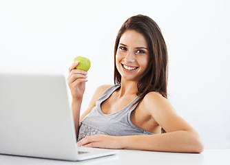 Image showing Laptop, portrait and woman nutritionist with apple in studio for wellness, diet or eating plan on white background. Weight loss, face and female health influencer with blog survey, help or menu guide