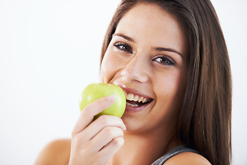 Image showing Woman, portrait and eating apple in studio for nutrition, healthy food and clean detox on white background. Face of happy model with fruits for vegan diet, vitamin c and lose weight on mockup space