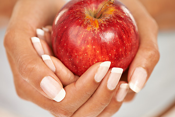 Image showing Hands, apple or food with a person closeup for health, diet or nutrition in the kitchen of her home. Fruit, nutritionist and hunger with an adult eating fresh produce for a healthy weight loss snack