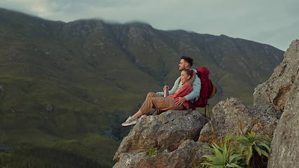 Image showing Hiking, mountains and view, couple relax on outdoor adventure and peace in nature with romance. Trekking, climbing and love, man and woman with view of natural landscape sitting on rocks together.