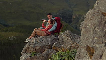 Image showing Hiking, mountain and drinking water, couple relax on outdoor adventure and peace in nature with romance. Trekking, rock climbing and love, man and woman with view of natural cliff with sharing drink.