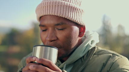 Image showing Coffee, camping and relax with black man in nature for adventure, travel and vacation. Morning, freedom and holiday with person drinking tea from mug in outdoors for peace, happy and smile