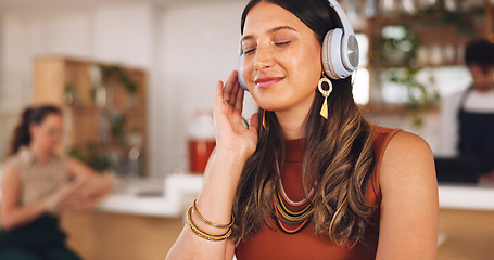 Image showing Music, freelance and woman in coffee shop with headphones, connection and streaming with smile. Relax, technology and remote work, happy girl in cafe listening to audio, radio or motivation podcast.
