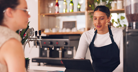 Image showing Women, barista or customer order at cafe for service, payment or order on counter at coffee shop. Serving, waitress or employee in small business restaurant helping a girl client at checkout or work