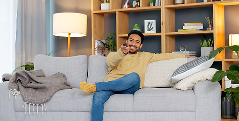 Image showing Watching tv, streaming and subscription with a man on a sofa in the living room of his home to relax. Television, video and remote with a young person changing the movie channel in his apartment
