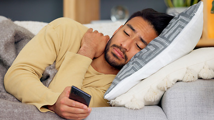 Image showing Man, phone and blanket on sofa in home living room, tired and web chat with email notification. Guy, smartphone and sick with research for health, medicine and watch video on social media in house