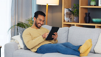 Image showing Happy, relax and asian man with a tablet a sofa for social media, chat or streaming at home. Digital, app and Japanese male in a living room smile for gif, meme or web, post and online communication