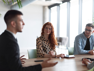 Image showing A diverse group of business professionals gathered at a modern office for a productive and inclusive meeting