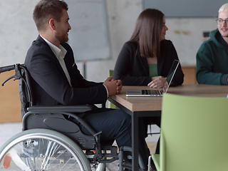 Image showing Close up photo of a diverse group of business professionals, including an person with a disability, gathered at a modern office for a productive and inclusive meeting.