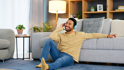 Image showing Podcast, man and headphones relax on living room floor listening to music or radio for happiness at home. Freedom, person and audio on carpet of apartment with smile for streaming online at house