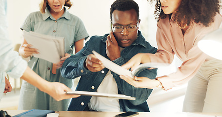 Image showing Business man, overwhelmed and hands with phone call, documents and support staff in busy office. Leader, manager or tired boss with notebook, paperwork and burnout with employee group with questions