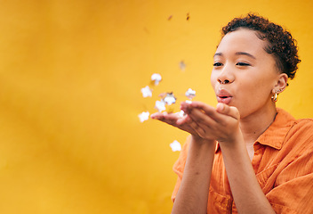 Image showing Blowing, petals and African woman on orange background for natural beauty, skincare and romance. Flowers, happy and female person with floral confetti for cosmetics, wellness and aesthetic in studio