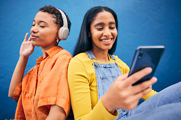 Image showing Phone, music and women in city on blue background online for social media, internet and streaming audio. Friendship, happy and female people relax on smartphone listening to song, track and radio