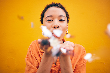 Image showing Flowers, petals and portrait of woman on orange background for natural beauty, skincare and romance. Blowing, happy and female person with floral confetti for cosmetics, makeup and wellness in studio