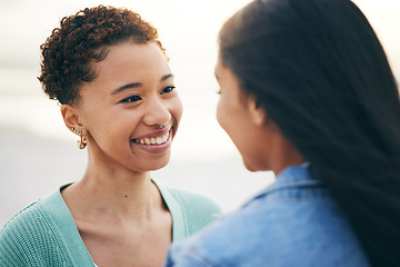 Image showing Sunset, beach and lesbian couple with love and smile together on an outdoor vacation or holiday for romance. Lgbtq, pride and women bonding on a summer date for adventure, relax and happiness