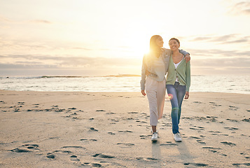 Image showing Love, beach and sunset, lesbian couple walking together on sand, sunset holiday adventure or hug on date. Lgbt women, bonding and relax on ocean vacation with romance, pride and happy nature travel.