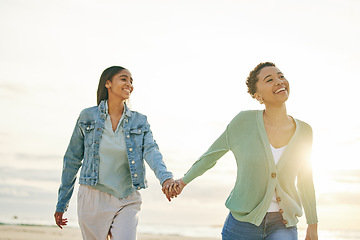 Image showing Love, beach and lesbian couple holding hands, walking together on sand and sunset holiday adventure. Lgbt women, bonding and relax on ocean vacation with romantic date, pride and happy nature travel.