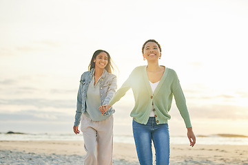 Image showing Love, ocean and lesbian couple holding hands, walking together and summer sunset holiday adventure. Lgbt women, bonding and relax on ocean vacation with romantic date, pride and happy nature travel.