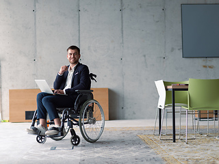 Image showing A businessman with disability in a wheelchair using laptop in a modern office