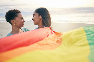 Image showing Pride flag, lesbian couple and freedom smile at beach for romance, happy or care in nature. Rainbow, love and women at ocean embrace lgbt, gay or partner pride, date or romantic relationship moment