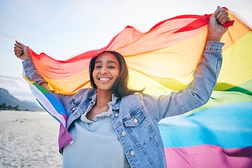 Image showing Woman, beach and rainbow flag for lgbtq in portrait, smile and wind with wave, pride and equality for inclusion. Student girl, fabric or cloth for human rights, lesbian sexuality or happy on vacation