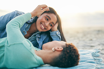 Image showing Love, beach and lesbian couple lying on blanket together, embrace on sand and sunset holiday adventure. Lgbt women, bonding and relax on ocean vacation with romance, pride and happy picnic in nature.