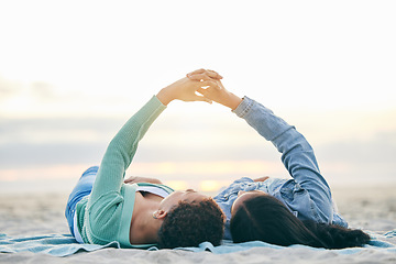 Image showing Love, ocean and lesbian couple on blanket holding hands on sand, summer and sunset holiday adventure. Lgbt women, bonding and relax on beach picnic date with romance, pride and happy lying in nature.