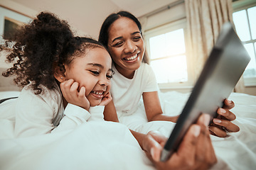 Image showing Mother watching a film on a tablet with her kid in the bed to relax, rest and bond together Happy, smile and young mom streaming movie or video on social media on digital technology with kid at home.