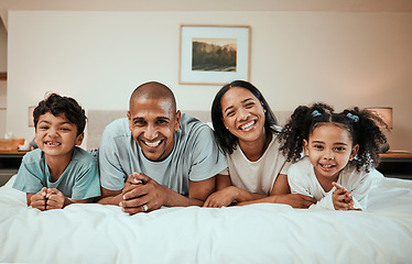 Image showing Happy, smile and portrait of a family on a bed for relaxing, resting and bonding together. Happiness, love and children laying with their young mother and father in the bedroom of their modern home.