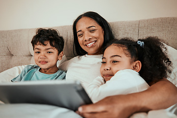 Image showing Mother watching a movie on a tablet with her children in the bed to relax, rest and bond. Happy, smile and young mom streaming a show or video on social media on digital technology with kids at home.