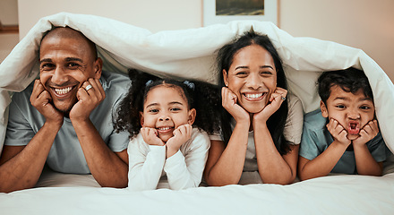 Image showing Happy, love and portrait of a family in bed with a blanket relaxing, resting and bonding at home. Happiness, smile and young children laying with their mother and father in the bedroom of their house