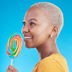 Image showing Lollipop, thinking and a woman with candy in studio for sweets, rainbow and creative idea. Profile of happy black female person isolated on a blue background with sugar, freedom and smile or color