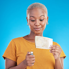 Image showing Burning, money and woman with euro bills on fire, flame or college student with debt in financial crisis on blue background. Inflation, increase or African customer spending credit with interest rate