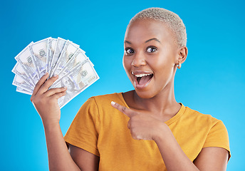 Image showing Black woman, pointing at cash fan and surprise with finance, payment and lottery win isolated on blue background. Female person with wow face, money and financial freedom, dollar bills in a studio