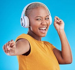 Image showing Black woman, headphones and dance, listen to music and energy with happiness isolated on blue background. Female person, wireless tech and radio with fun, dancer with freedom and streaming in studio