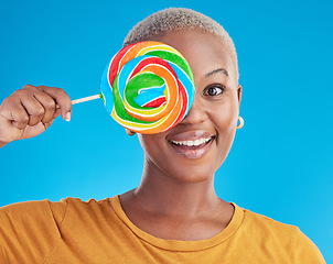 Image showing Portrait, cover and black woman with a lollipop, candy and happiness on a blue studio background. Face, happy female person and African model with sugar treats, confectionary and cheerful girl