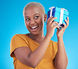 Image showing Shake gift, excited black woman with box and studio isolated on a blue background. Curious, happy and African person with present for party, celebration of holiday or birthday package for giveaway