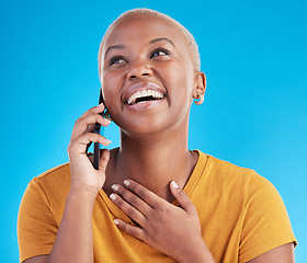 Image showing Phone call, good news or happy black woman in studio on blue background talking for communication. Mobile, face or African girl listening or calling to chat in conversation or speaking of funny joke