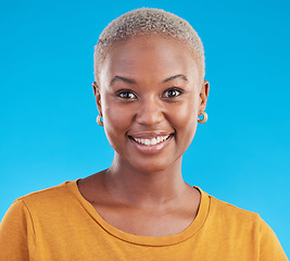 Image showing Face, fashion and happy black woman in tshirt isolated on a blue studio background. Portrait, smile and young African person, model or girl from Kenya with style and confidence in casual clothes