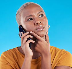 Image showing Black woman, phone call and thinking of college decision, listening to news or feedback on blue, studio background. Serious person or student on mobile communication with doubt, choice or idea emoji