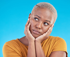 Image showing Thinking, sad and black woman with depression, decision or solution on a blue studio background. Person, alone or model with problem solving, thoughts or anxiety with mental health, unhappy or choice