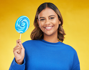 Image showing Happy, candy and portrait of a woman, lollipop and positive girl on a yellow studio background. Face, female person or model with sweets, snack and fun with mockup space, cheerful or joy with freedom